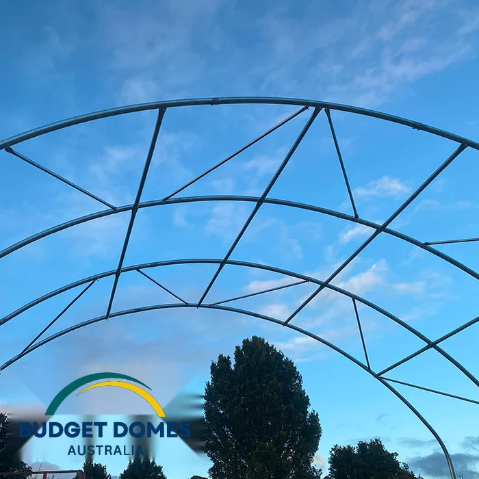 Exposed curved steel frame and bracing of a container dome shelter before the cover is fitted